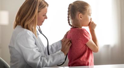 Doctor checking a child patient for a cough