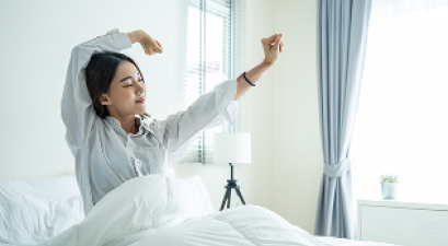 Woman stretching in bed and waking up