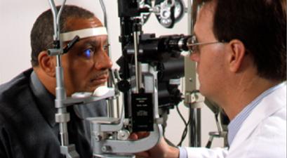 Un oculista examina los ojos de un hombre para detectar señales de enfermedades de los ojos durante un examen completo de los ojos.